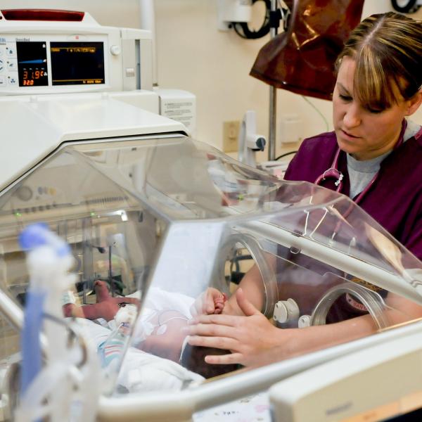 Nurse with a baby in an incubator