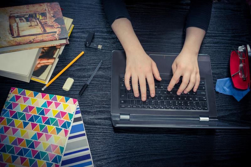 Hands working on a laptop